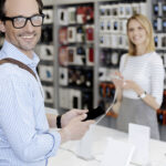 Ein Paar sucht sich im Kabelshop Stralsund ein neues Smartphone aus und informiert sich über die besten Tarfife.